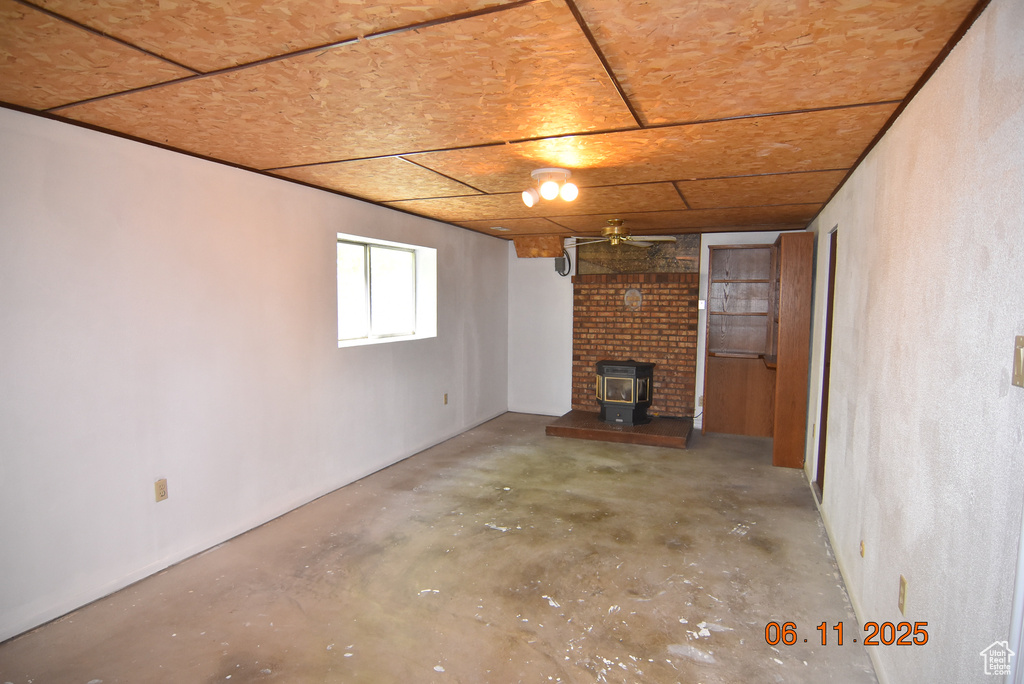 Basement with a wood stove and ceiling fan