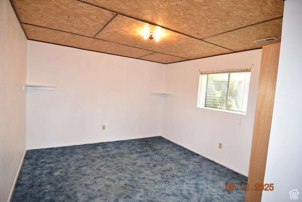 Spare room with dark colored carpet