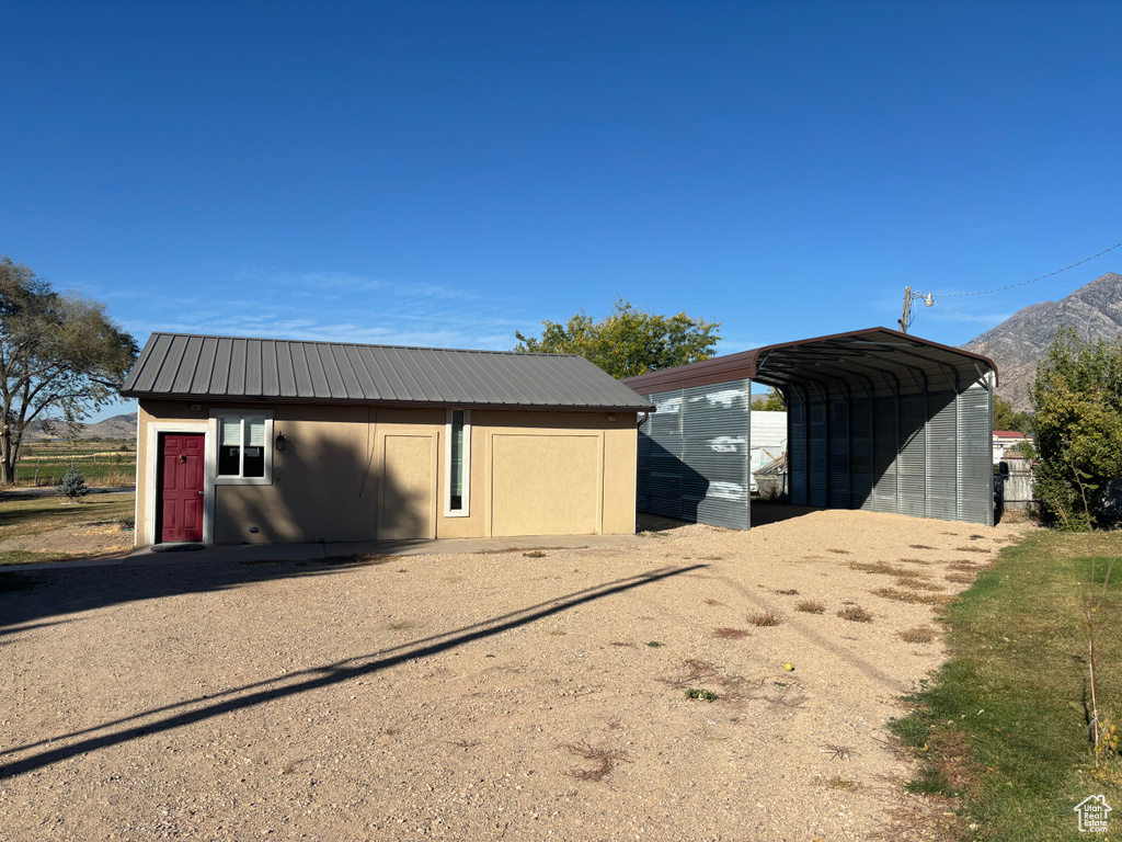 View of outdoor structure featuring a mountain view and a carport