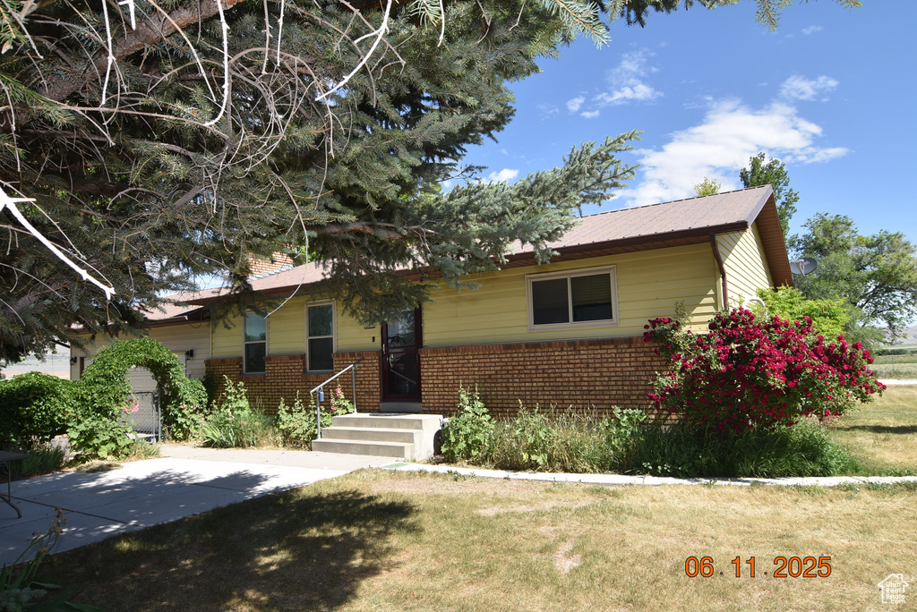 Ranch-style house featuring brick siding and a front yard