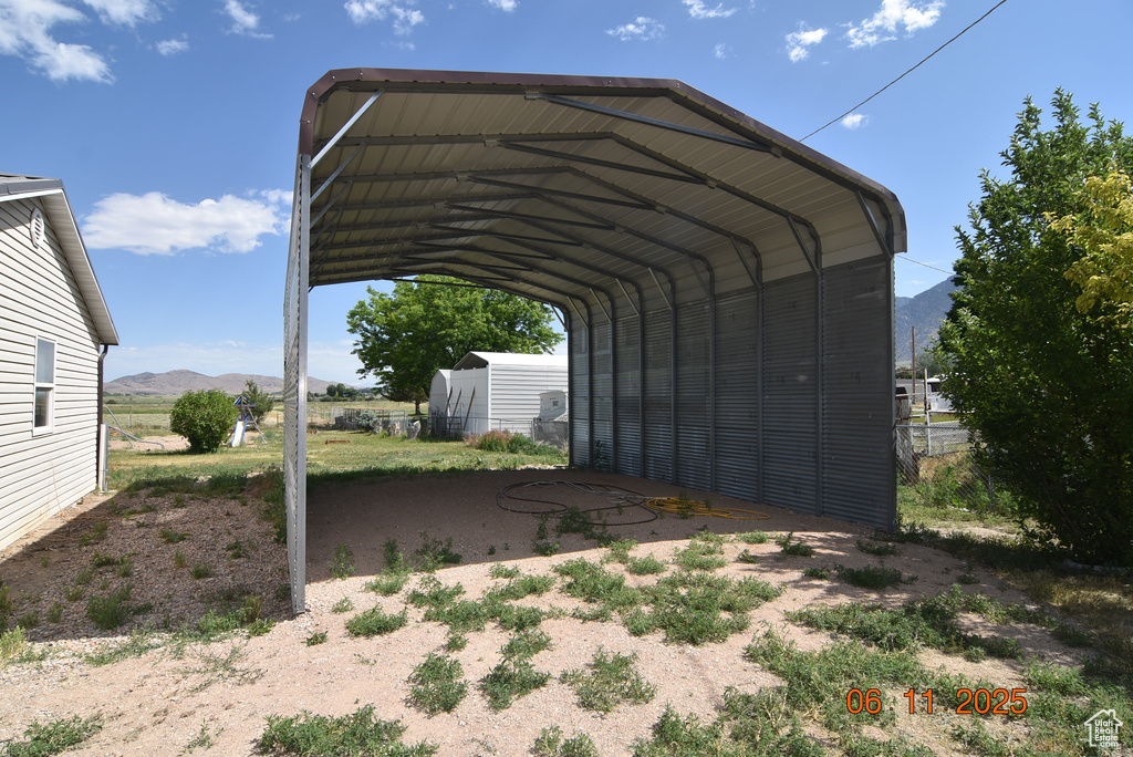 View of parking / parking lot with a detached carport and a mountain view