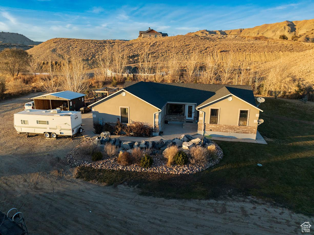 Back of property with a mountain view and a patio area