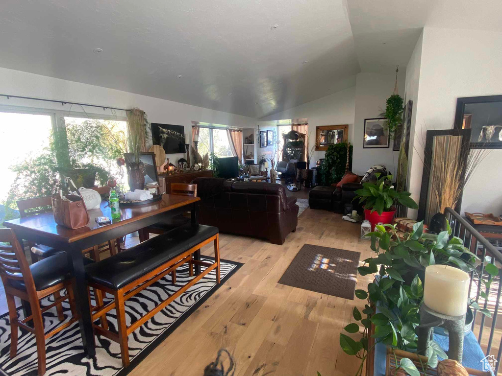 Dining space featuring a healthy amount of sunlight, vaulted ceiling, and light hardwood / wood-style floors