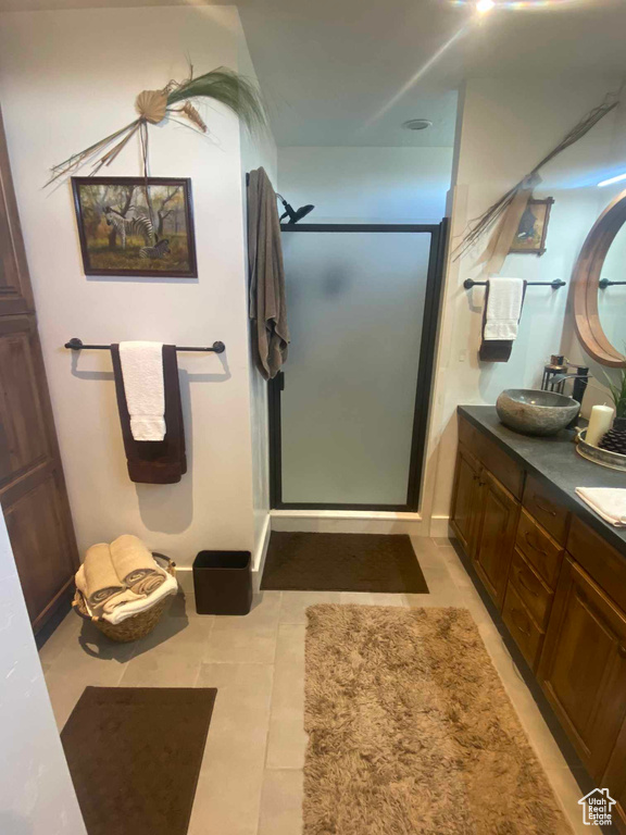 Bathroom with tile patterned floors, vanity, and walk in shower