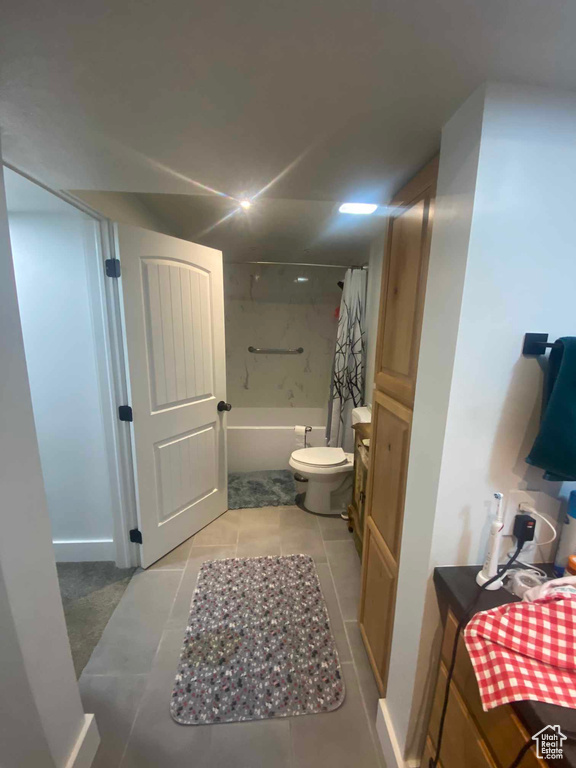 Full bathroom featuring tile patterned floors, shower / bath combination with curtain, toilet, and vanity