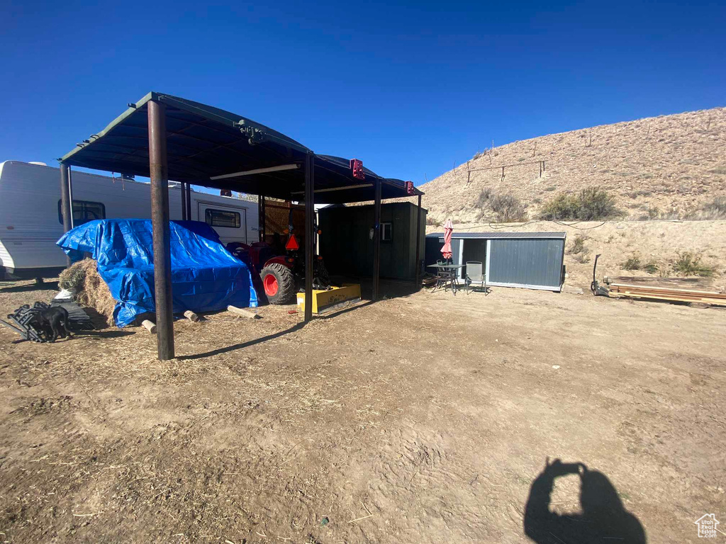 View of yard with a carport and a storage shed