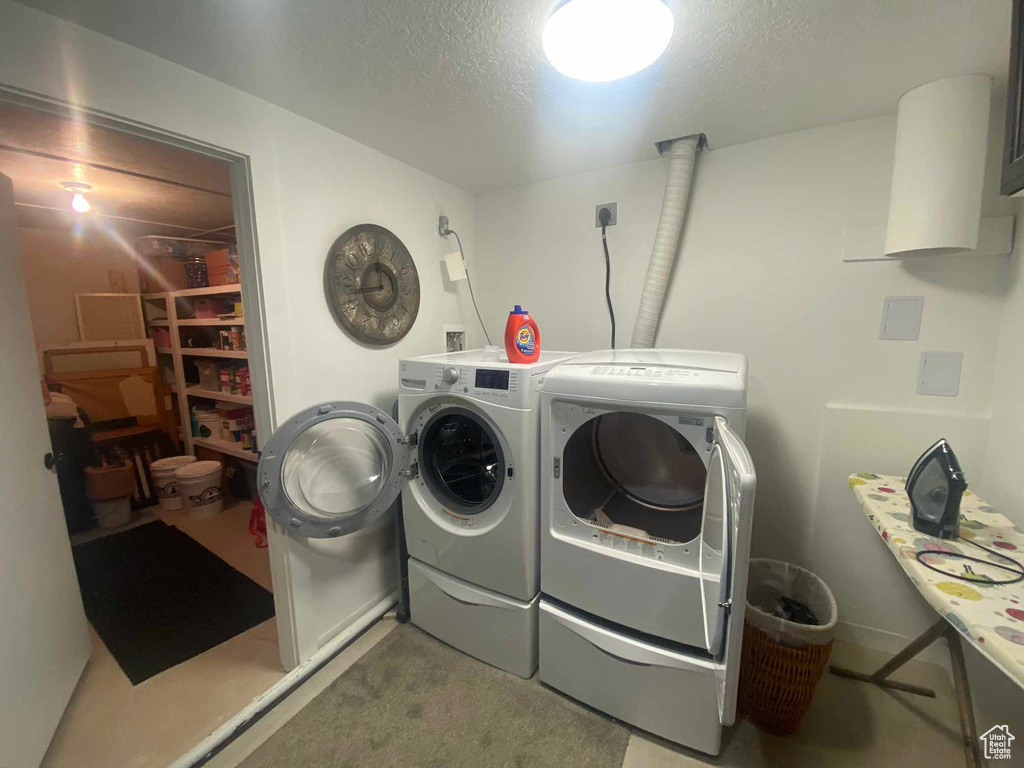 Laundry room with washer and dryer and a textured ceiling