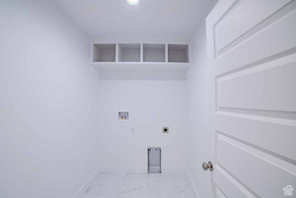 Clothes washing area with marble finish floor, laundry area, hookup for an electric dryer, baseboards, and hookup for a washing machine