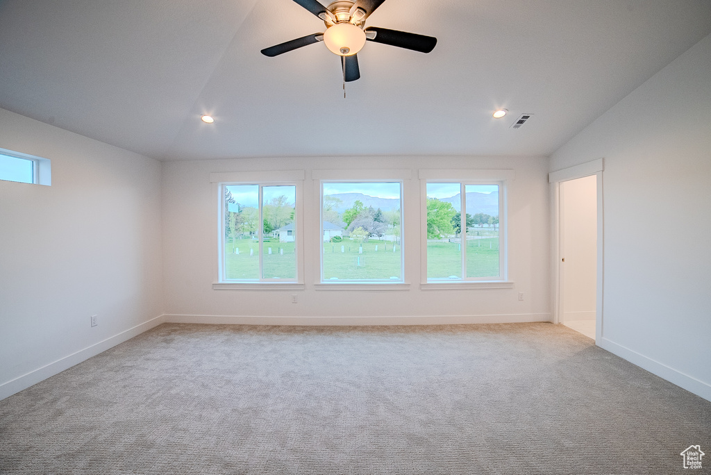 Spare room with carpet flooring, a wealth of natural light, baseboards, and lofted ceiling