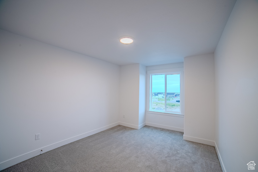Carpeted empty room with baseboards