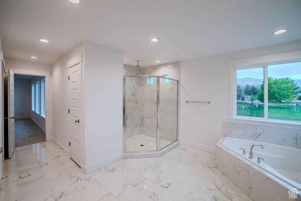 Bathroom with a marble finish shower, baseboards, and recessed lighting
