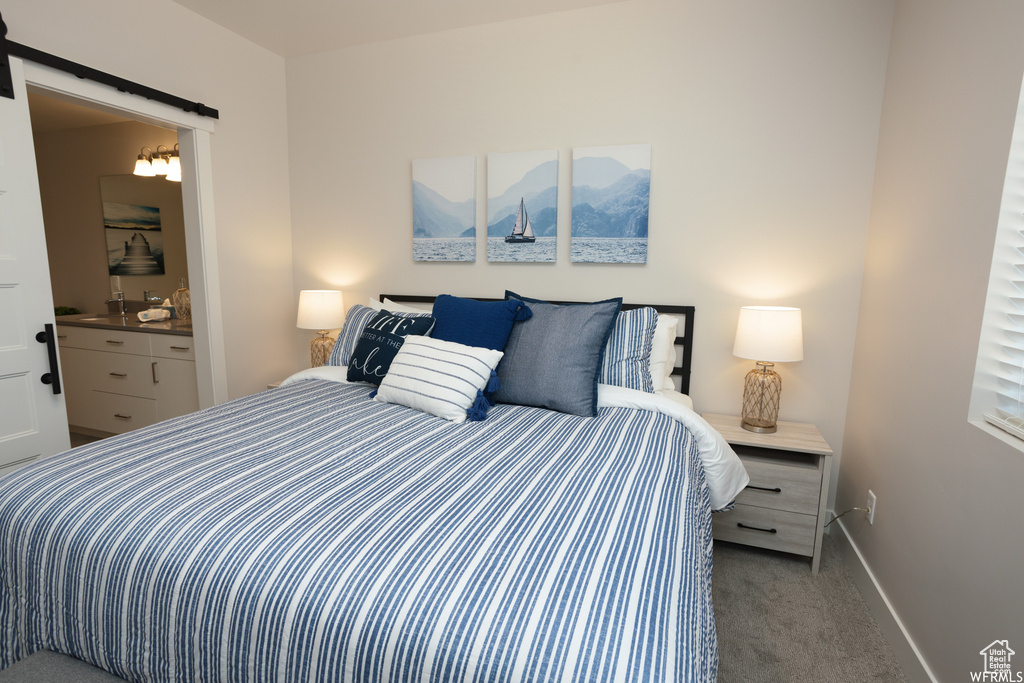 Carpeted bedroom featuring ensuite bathroom