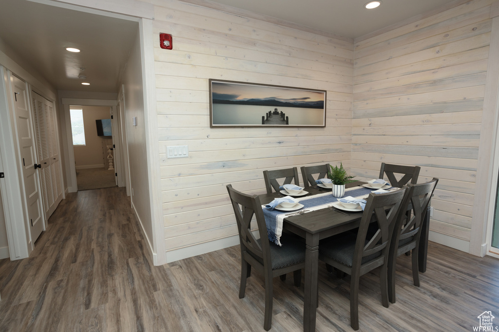 Dining room featuring wood-type flooring and wood walls