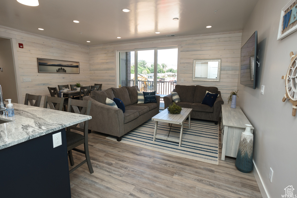 Living room featuring wood walls and light hardwood / wood-style flooring