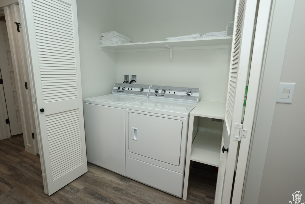 Clothes washing area with dark hardwood / wood-style floors and independent washer and dryer