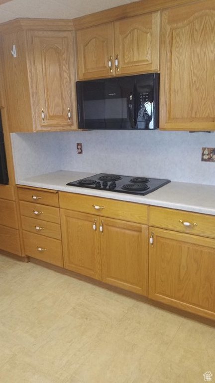 Kitchen featuring black appliances and backsplash