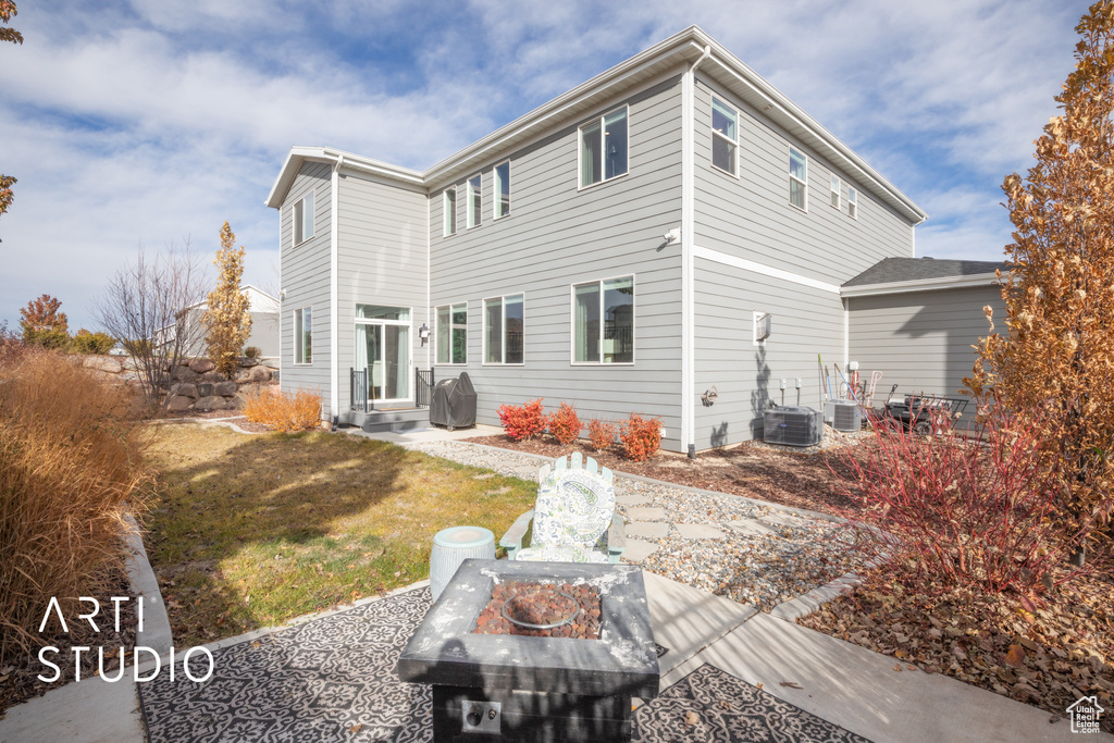 Rear view of property featuring a lawn and cooling unit