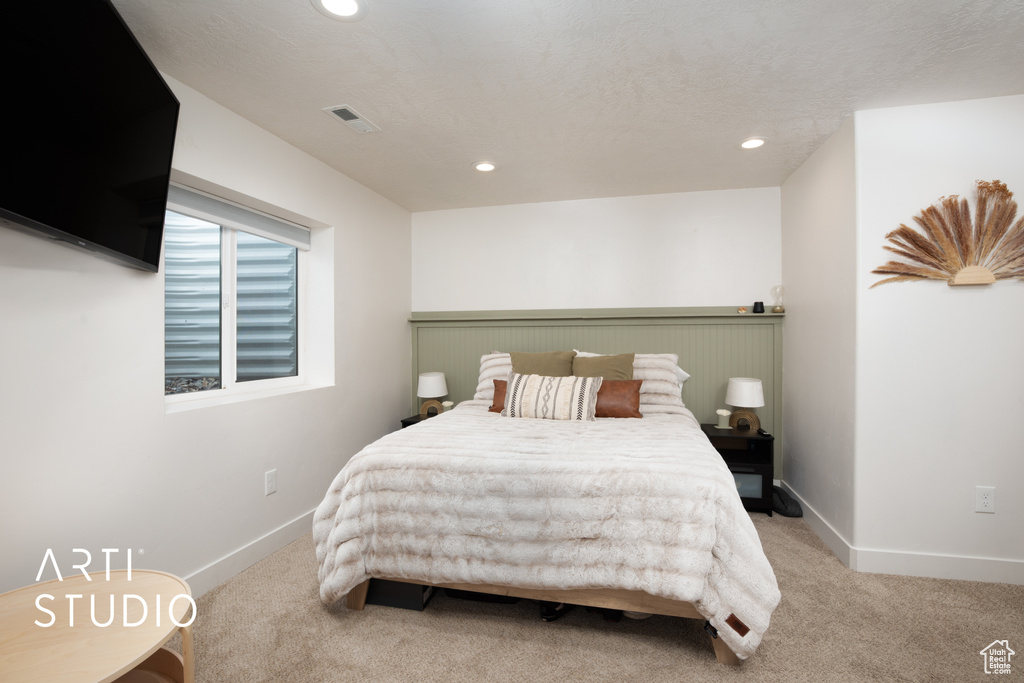 Carpeted bedroom with a textured ceiling