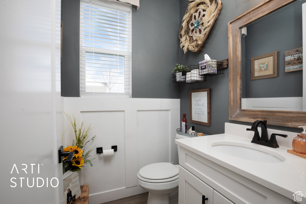 Bathroom featuring hardwood / wood-style flooring, vanity, and toilet