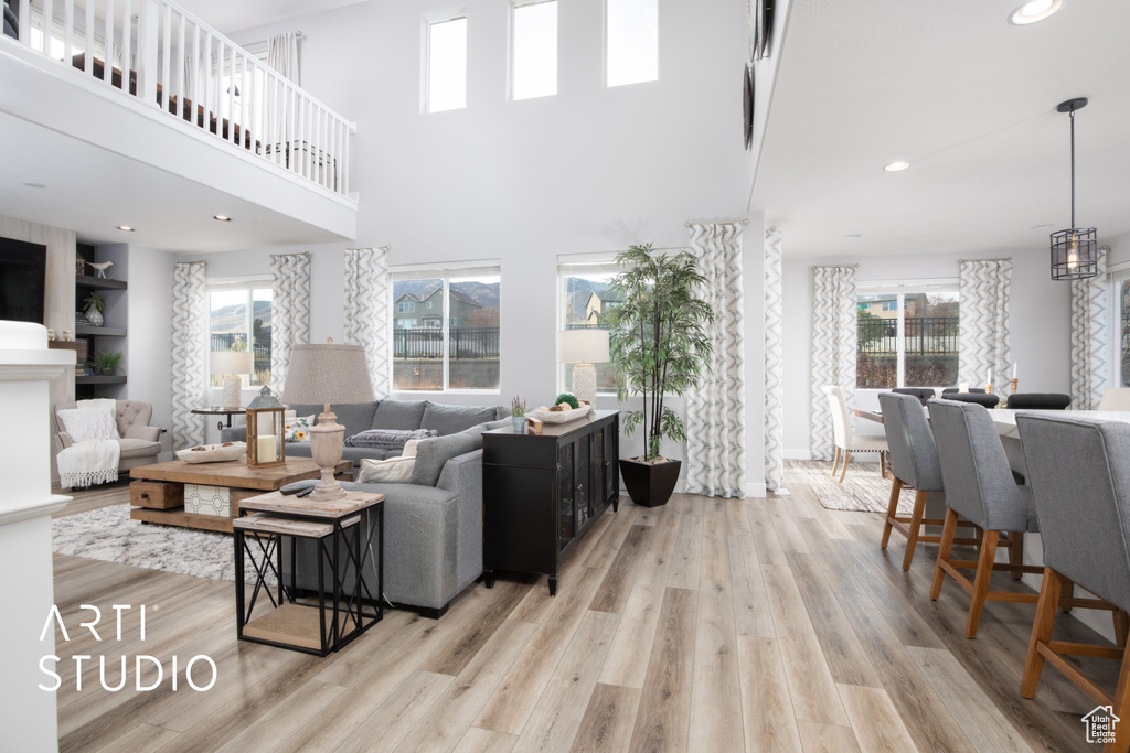 Living room featuring light wood-type flooring and a high ceiling