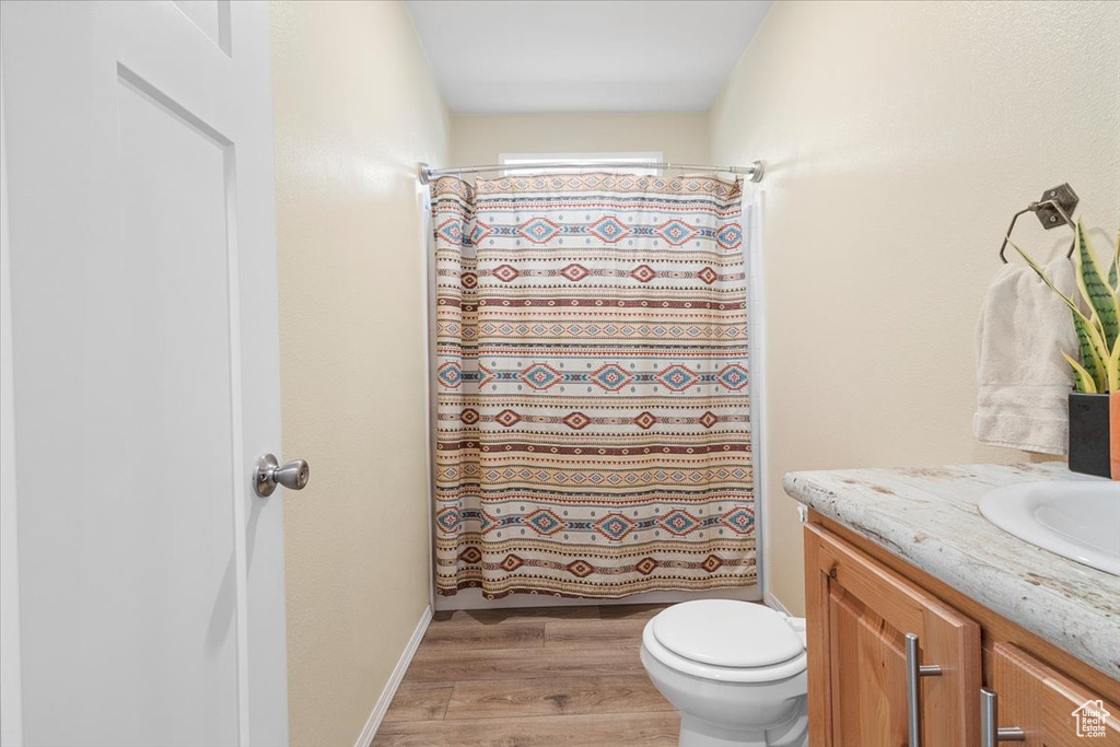 Bathroom featuring hardwood / wood-style floors, vanity, and toilet