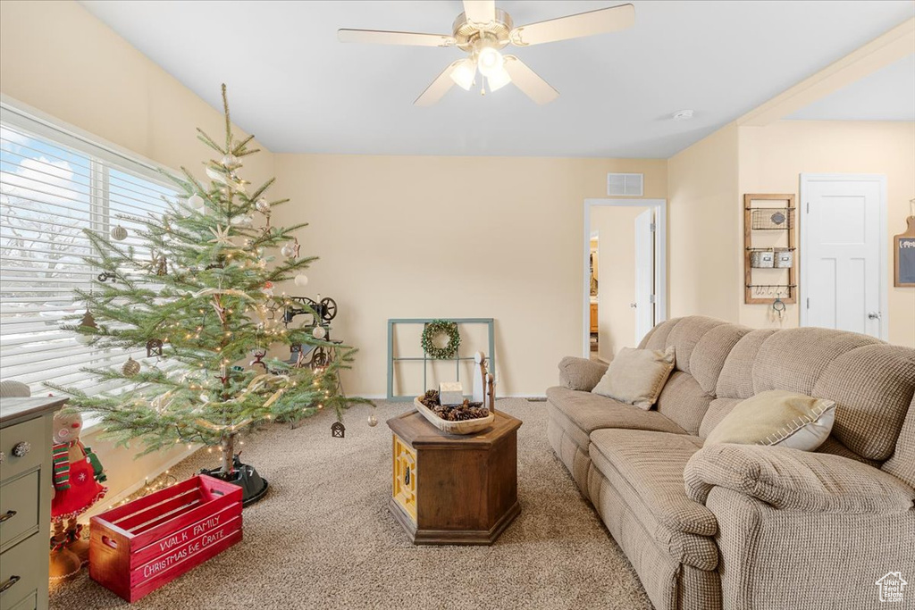 Carpeted living room featuring ceiling fan