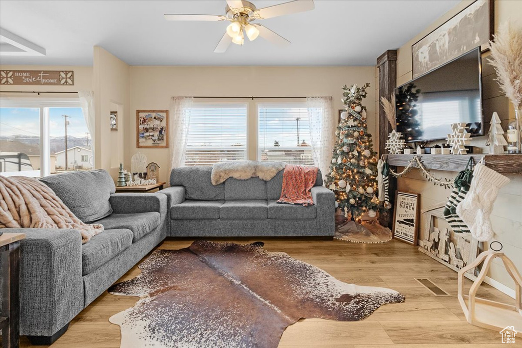 Living room with ceiling fan and light wood-type flooring