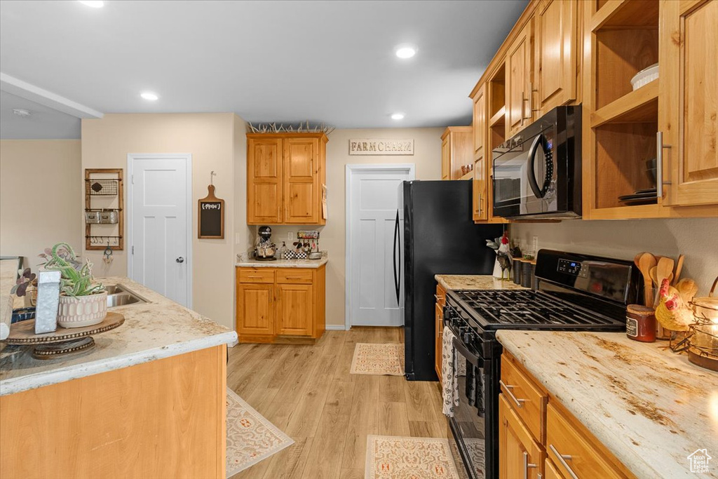 Kitchen with wooden counters, black appliances, and light wood-type flooring
