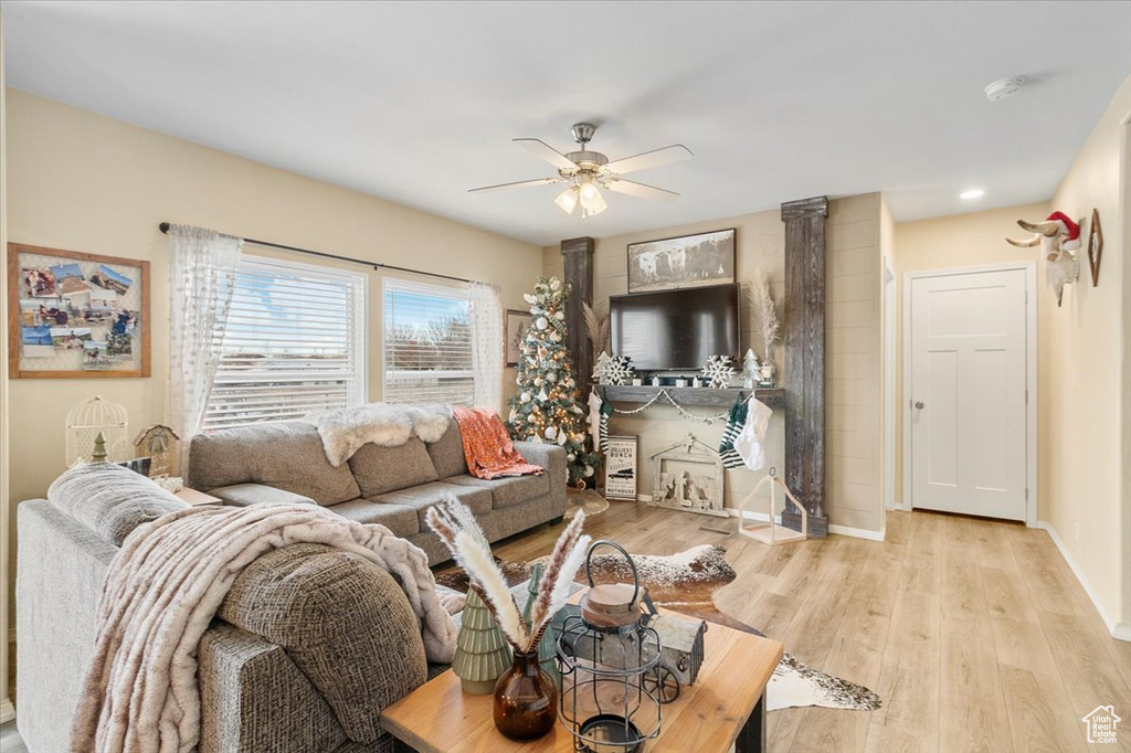 Living room with ceiling fan and light wood-type flooring