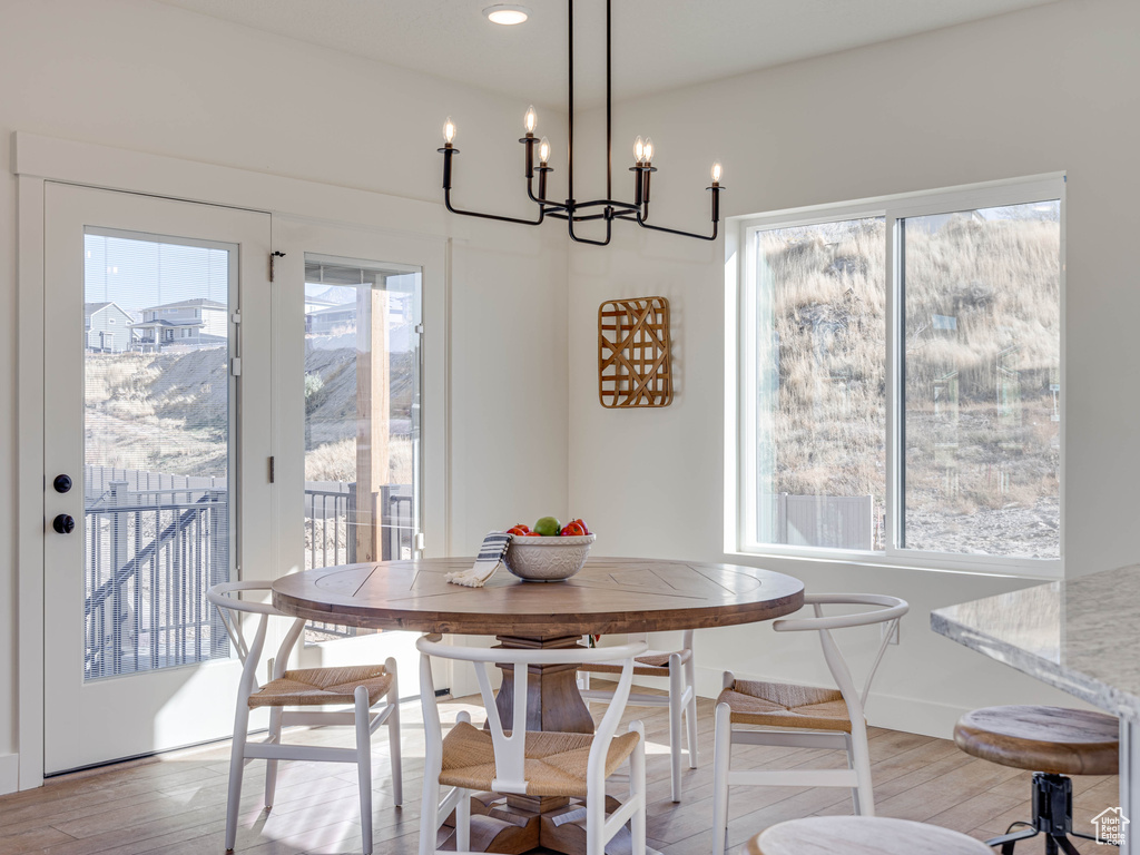 Dining area with baseboards, an inviting chandelier, recessed lighting, and light wood finished floors