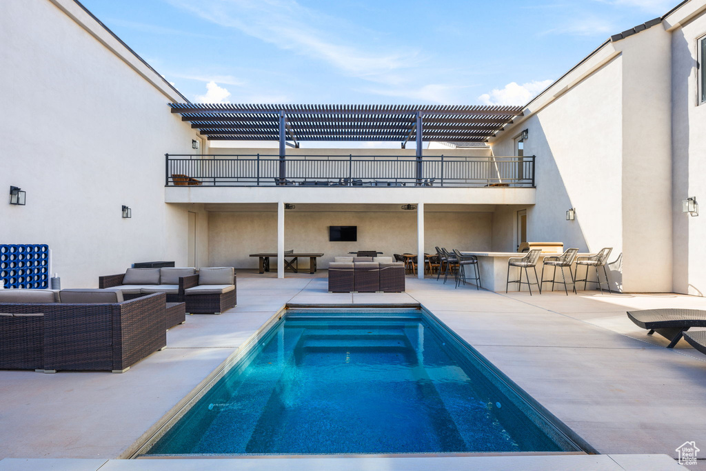 View of pool featuring exterior bar, outdoor lounge area, and a patio