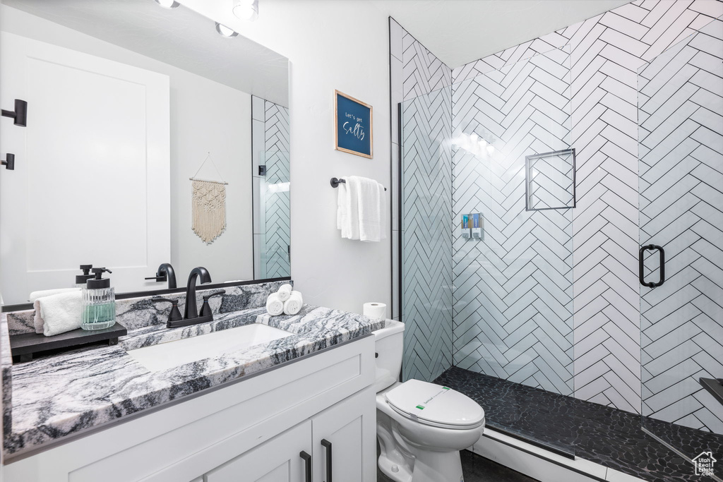 Bathroom featuring vanity, toilet, an enclosed shower, and a baseboard heating unit