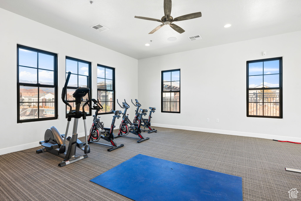 Exercise room with ceiling fan and carpet floors