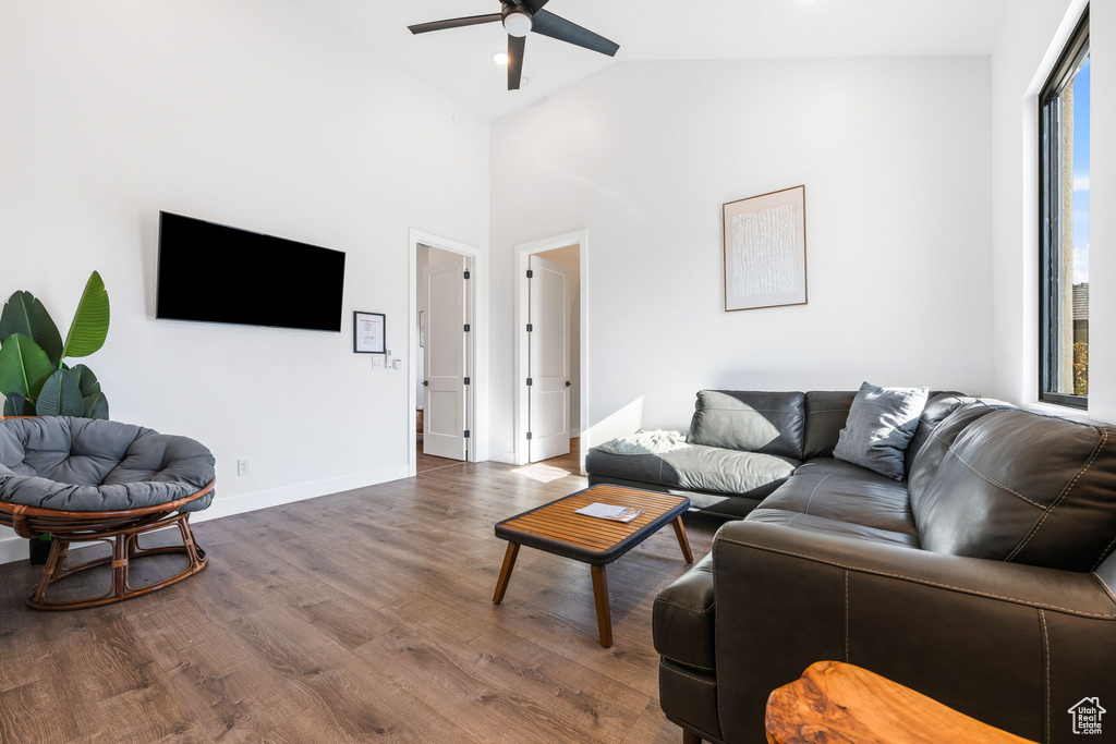 Living room featuring ceiling fan, wood-type flooring, and high vaulted ceiling