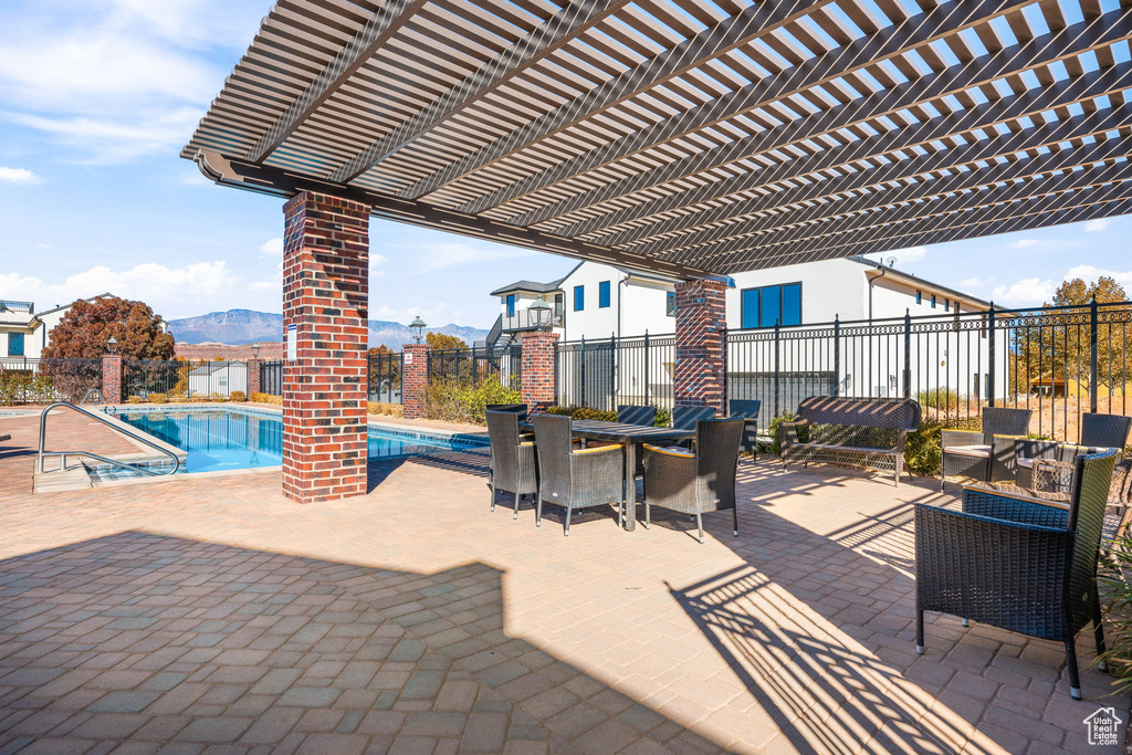 View of patio featuring a mountain view, a pergola, and a community pool