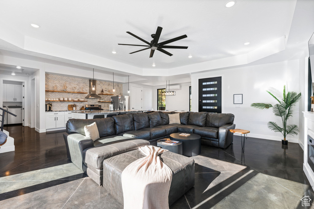 Living room with a tray ceiling and ceiling fan
