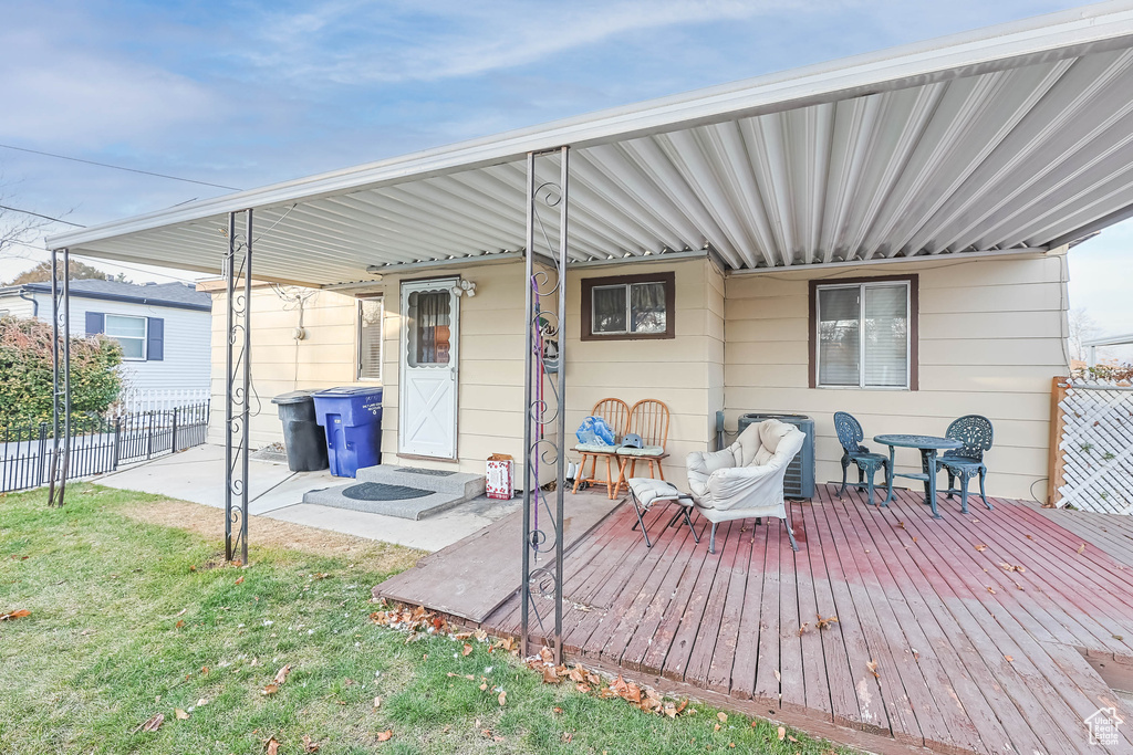 Back of property featuring a lawn and a wooden deck