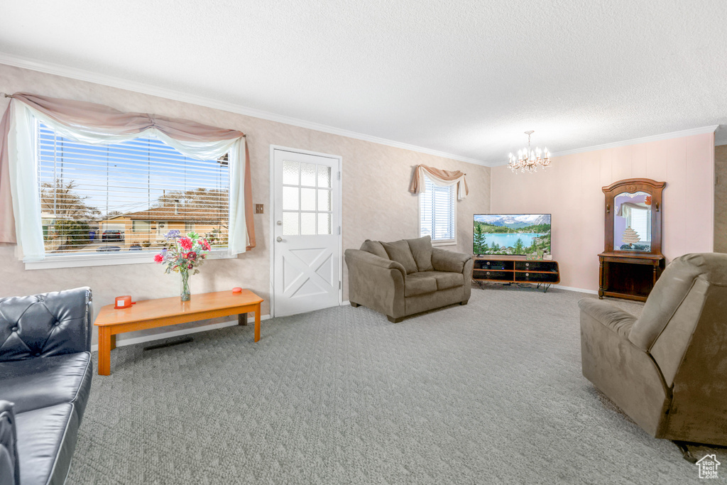 Carpeted living room with a textured ceiling, an inviting chandelier, and crown molding