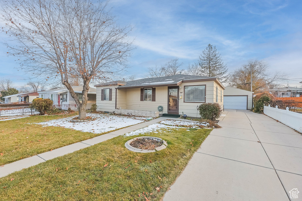 Single story home with a front lawn and an outdoor structure