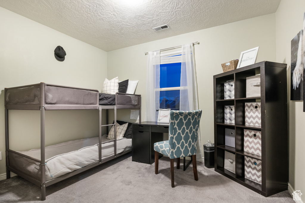 Bedroom with carpet flooring and a textured ceiling