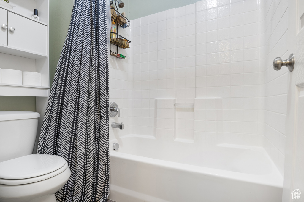 Bathroom featuring shower / tub combo and toilet