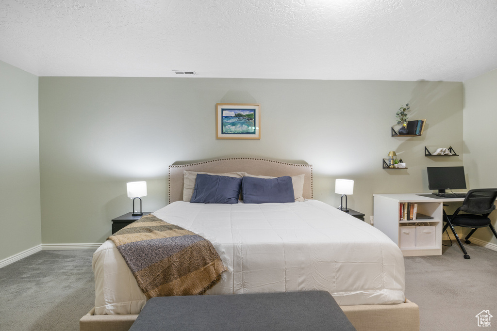 Carpeted bedroom with a textured ceiling