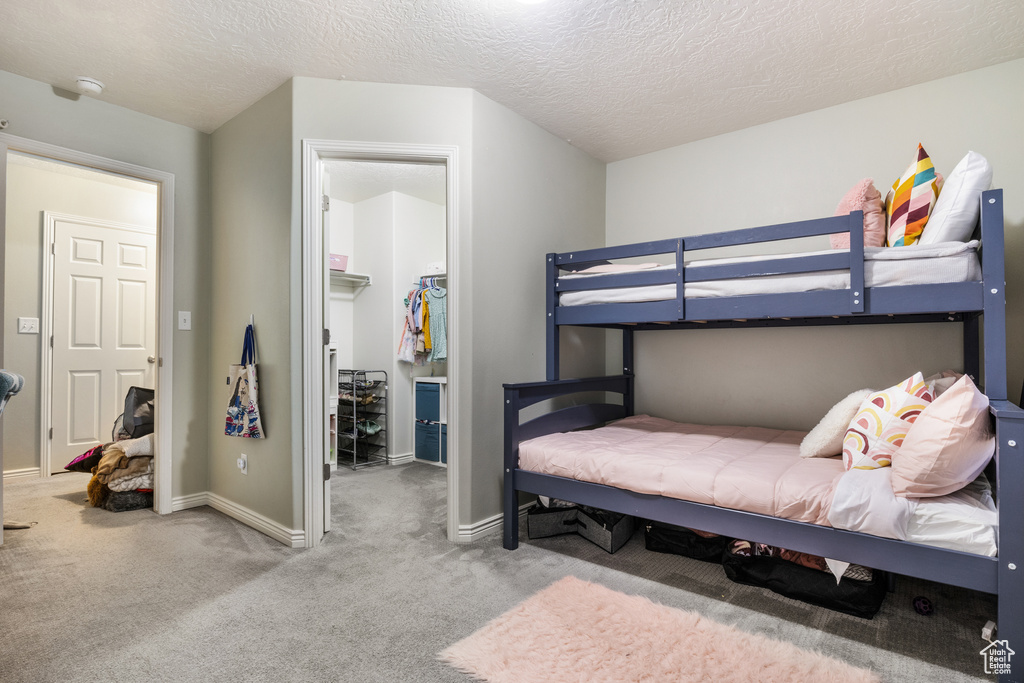 Carpeted bedroom with a closet and a textured ceiling
