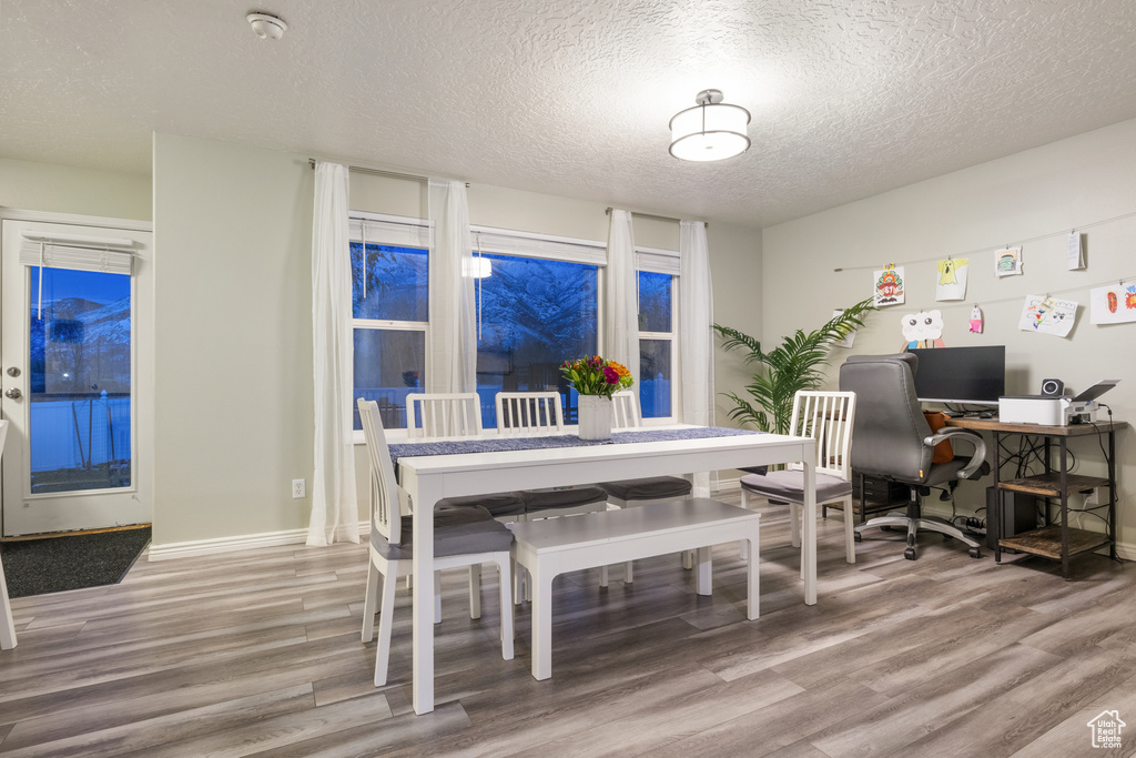 Dining room with a textured ceiling and hardwood / wood-style flooring