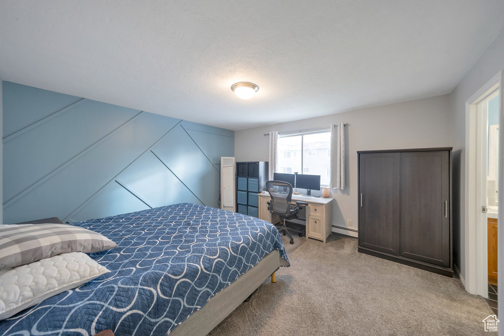 Bedroom featuring a textured ceiling and light colored carpet