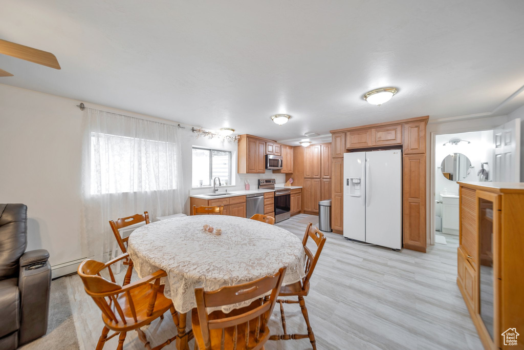Dining room featuring light hardwood / wood-style floors, sink, and a baseboard heating unit