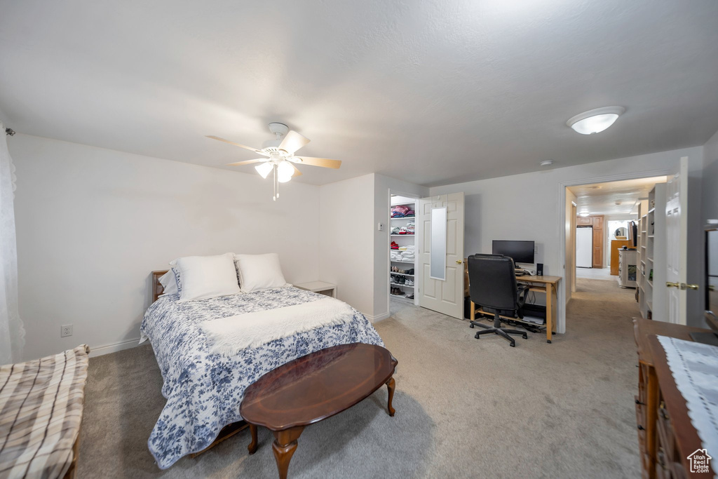 Carpeted bedroom with a closet, a spacious closet, and ceiling fan