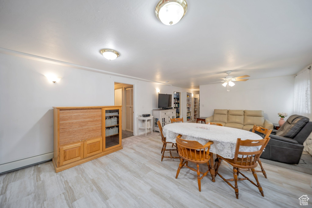 Dining area featuring ceiling fan, light hardwood / wood-style flooring, and a baseboard radiator