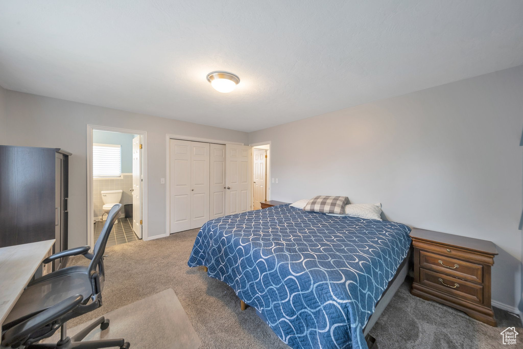 Bedroom featuring carpet flooring, ensuite bath, and a closet