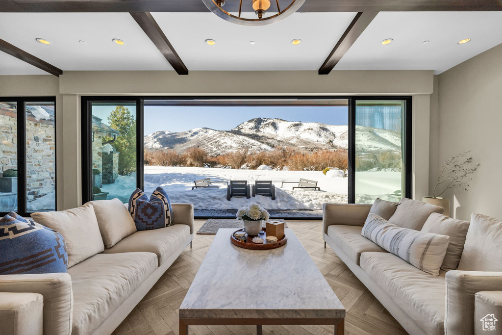 Living room with a mountain view, beamed ceiling, light parquet flooring, and plenty of natural light
